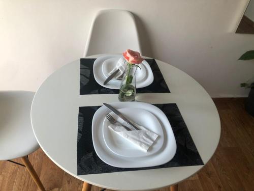 a table with two plates and a rose on it at la perle de martil in Martil