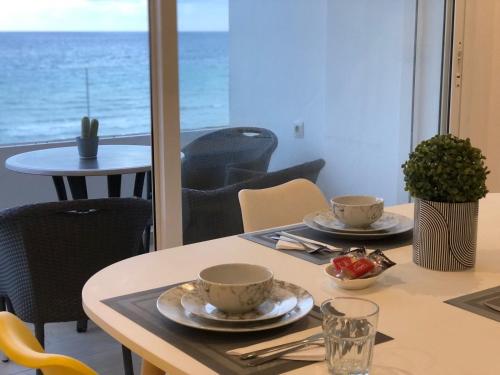 a table with two cups and a bowl of fruit on it at la perle de martil in Martil