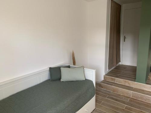 Cette petite chambre comprend un lit et un escalier. dans l'établissement Charmante studette au cœur du Plessis Robinson, au Plessis-Robinson