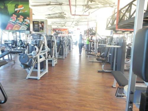 a gym with rows of tread machines and a person walking down the aisle at apart hotel 2 quartos frente mar in Salvador