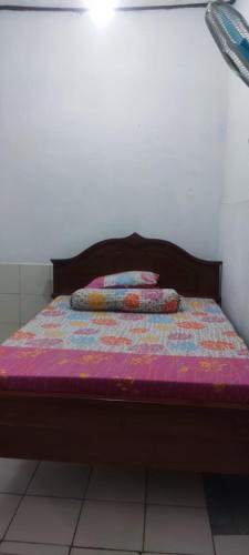 ein Bett mit einer lila Decke und Kissen darauf in der Unterkunft Homestay H mamun in Cilowa
