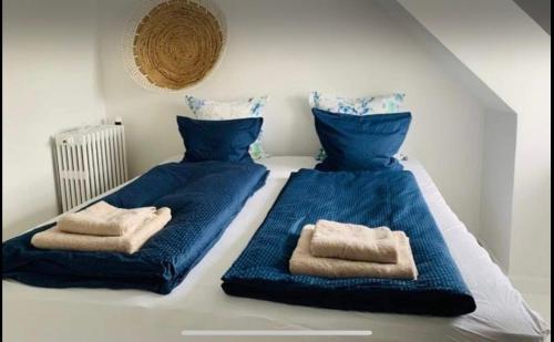 een bed met blauwe lakens en handdoeken erop bij Danish villa with a lovely garden & close to Copenhagen in Gentofte