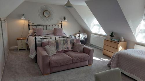 a bedroom with a bed and a chair and a couch at Westwood Lodge B & B Boston in Boston
