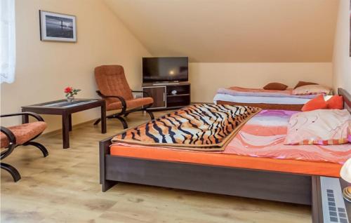 een slaapkamer met 2 bedden, een tv en een stoel bij Nice Apartment In Lokciowe With Kitchen in Łokciowe