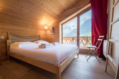 1 dormitorio con cama y ventana grande en Chalet Panorama, en Chamonix-Mont-Blanc
