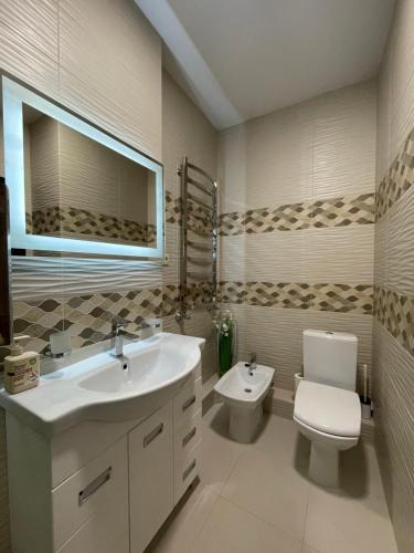 a bathroom with a white sink and a toilet at Затишні сучасні апартаменти в елітному ЖК Версаль in Truskavets