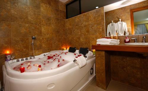 Hotel Club del Sol في أتاكاميس: حمام مع حوض أبيض كبير وعليه دم