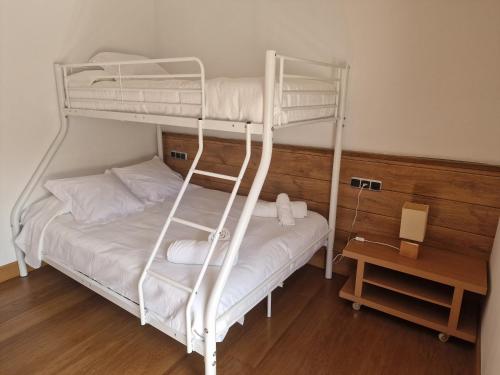 a bedroom with two bunk beds and a table at Hostal Lizuniaga in Bera
