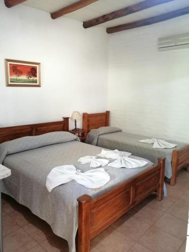 um quarto com 2 camas e toalhas brancas em Hotel Rural Luna del Valle em San Agustín de Valle Fértil