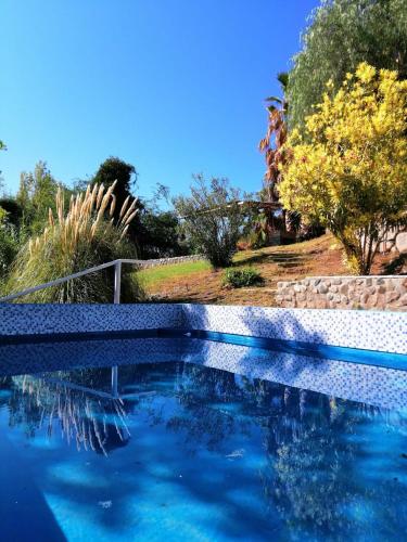 a swimming pool with blue water in a yard at Hotel Rural Luna del Valle in San Agustín de Valle Fértil