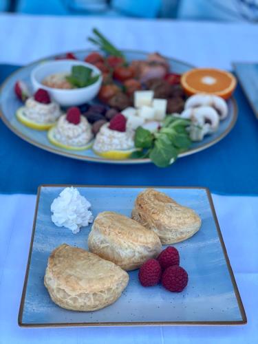 a plate of food with biscuits and berries on a table at Pensiunea Știuca Șchioapă in Băltenii de Sus