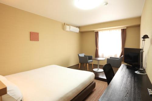 a hotel room with a bed and a television at Smile Hotel Otsu Seta in Otsu