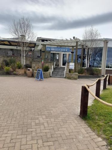 a building with a blue sign in front of it at Atlas By The Sea - Craig Tara, Ayr in Ayr