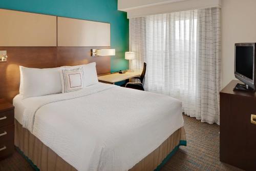 a hotel room with a large bed and a desk at Residence Inn Dallas DFW Airport North/Irving in Irving