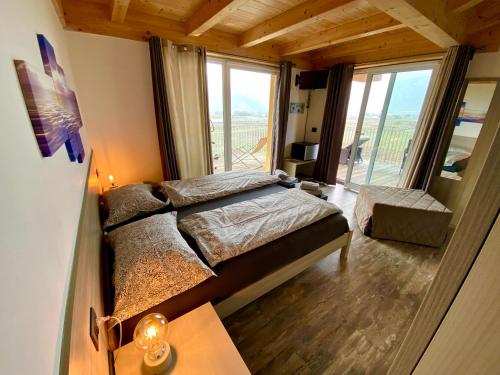 a bedroom with a bed and a large window at B&B A.R.C.O. in Arco