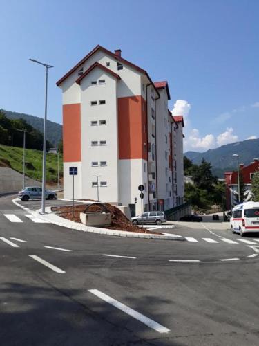 a building on the side of a street with a parking lot at Vista apart Pluzine in Plužine