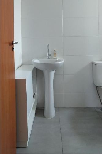 bagno bianco con lavandino e servizi igienici di Apartamento Vert808 a Lajeado