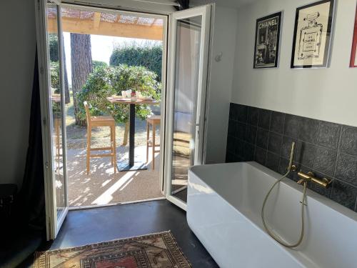 baño con bañera y puerta corredera de cristal en Maison "LA ROSALINDA-2B" Ghisonaccia, en Ghisonaccia