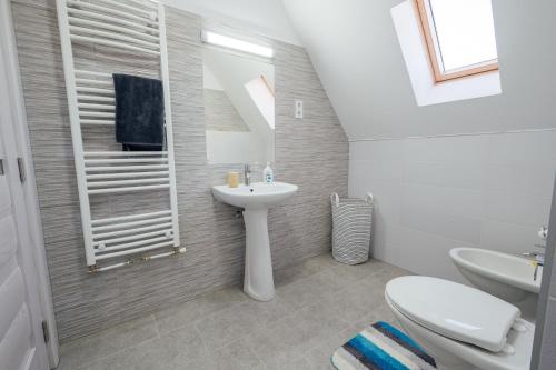 a white bathroom with a sink and a toilet at SkarabeuS in Odorheiu Secuiesc