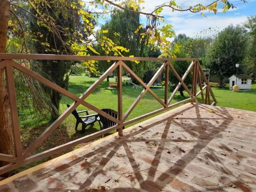 a wooden bridge with a bench in a park at Complejo Dulcería El Cazador y cabañas in Tandil