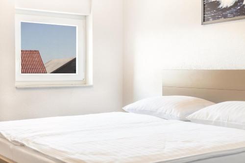 a white bed in a bedroom with a window at Apartments Delic in Ražanac