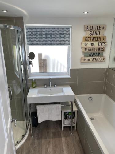 a bathroom with a sink and a shower and a tub at No1 The Cleave in Kingsand