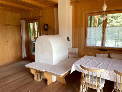a room with a bench and a table and a window at Chalet am Waldrand in Verano
