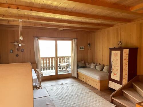 a living room with a bed and a large window at Chalet am Waldrand in Verano