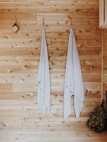 灣城的住宿－STAY Harless Hugh Luxury Home on River.，两条白色毛巾挂在木墙上