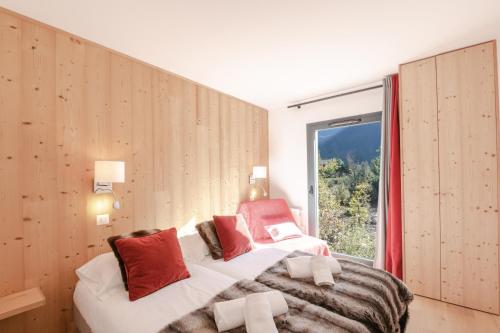 een slaapkamer met 2 bedden en een groot raam bij La Cordée in Chamonix-Mont-Blanc