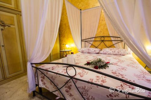 1 dormitorio con 1 cama con dosel y flores en Il Gallo, en Monopoli