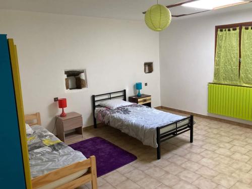 sypialnia z 2 łóżkami i fioletowym dywanem w obiekcie Gîte L'hirondelle w mieście Meyrueis