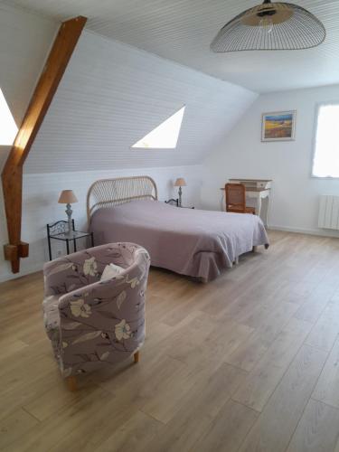 - une chambre avec un lit et une chaise dans l'établissement La Clé de Line, à Saint-Aubin-sur-Mer