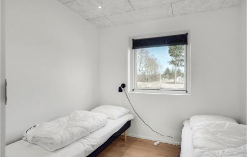 Zimmer mit 2 Betten und einem Fenster in der Unterkunft Nice Home In Blokhus With Sauna in Blokhus