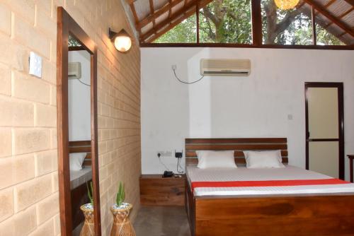Schlafzimmer mit einem Bett und einem Fenster in der Unterkunft Ranathisara Grand Cabanas in Kurunegala