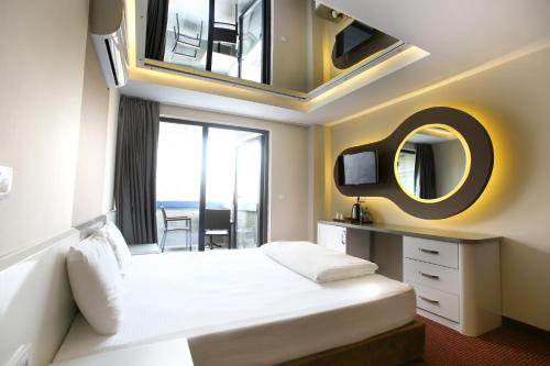 een hotelkamer met een bed en een spiegel bij IS Hotel in Antalya