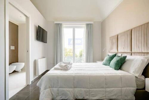 a white bedroom with a large bed and a window at Shoruq in Marsala