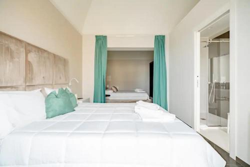 a bedroom with a large white bed with blue curtains at Shoruq in Marsala