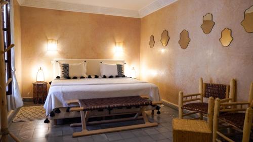 a bedroom with a large bed and two chairs at Monriad in Marrakech