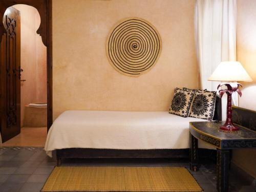 a bedroom with a bed and a table with a lamp at Monriad in Marrakech