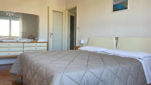 a white bedroom with a large bed and a window at MAX and SEA parking in Sanremo