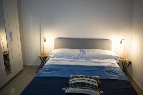 a bedroom with a bed with two lamps on two tables at Mimosa House in Turin