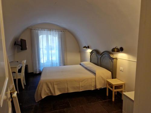 Schlafzimmer mit einem Bett, einem Tisch und einem Fenster in der Unterkunft B&B L'Orto Sul Tetto in Ragusa