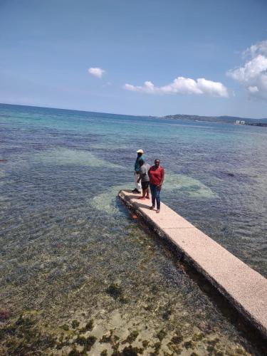 two people standing on a pier in the water at Chateau Margarita JA in Montego Bay