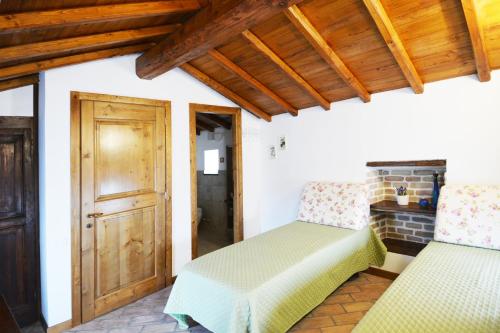 a room with two beds and a wooden ceiling at La casetta degli agricoltori in Vetralla