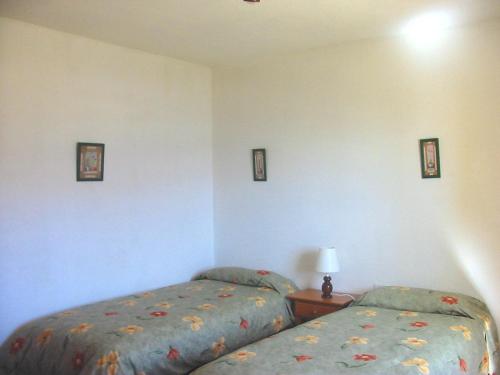 1 dormitorio con 2 camas y mesa con lámpara en Casa Time, en Tijarafe