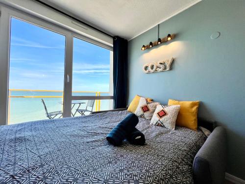 a bedroom with a bed with a view of the ocean at COC - Le Panorama in Wissant