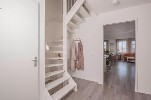 een witte trap in een kamer met een woonkamer bij Heuvel zicht in Oss