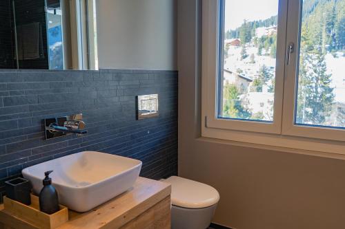 a bathroom with a white sink and a window at sunrise2sunset in Arosa