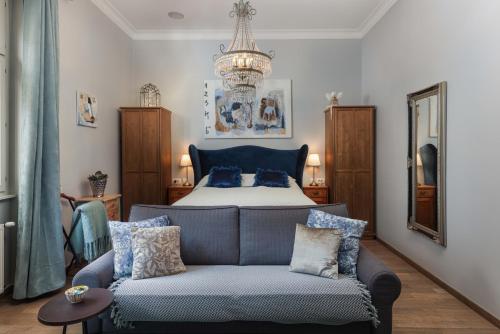 a bedroom with a bed and a couch and a chandelier at 3on7 Apartments in Zagreb